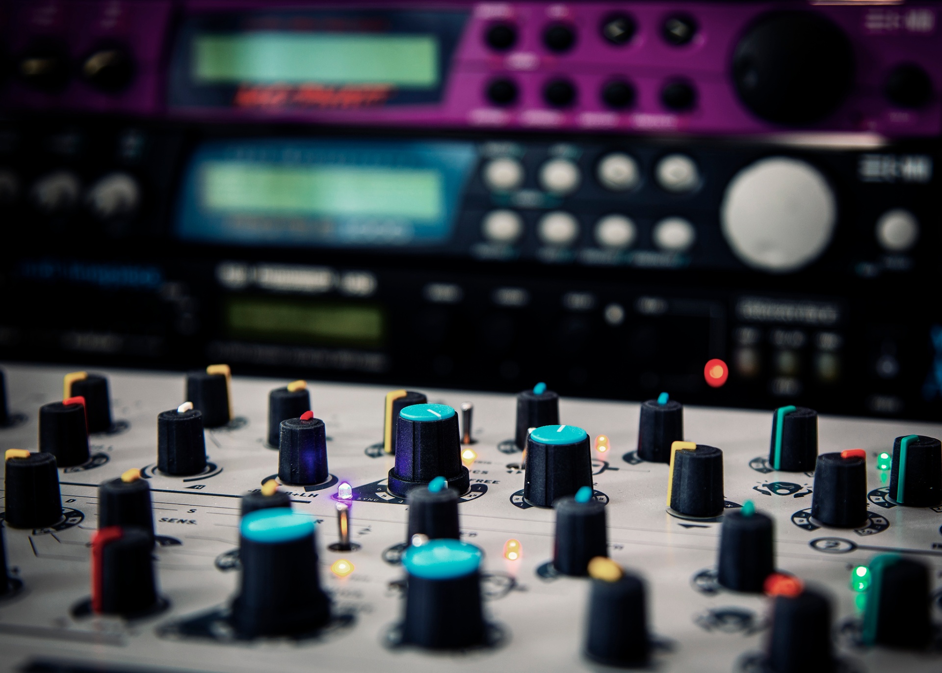 Synthesizer knobs and LEDs in a darkened studio